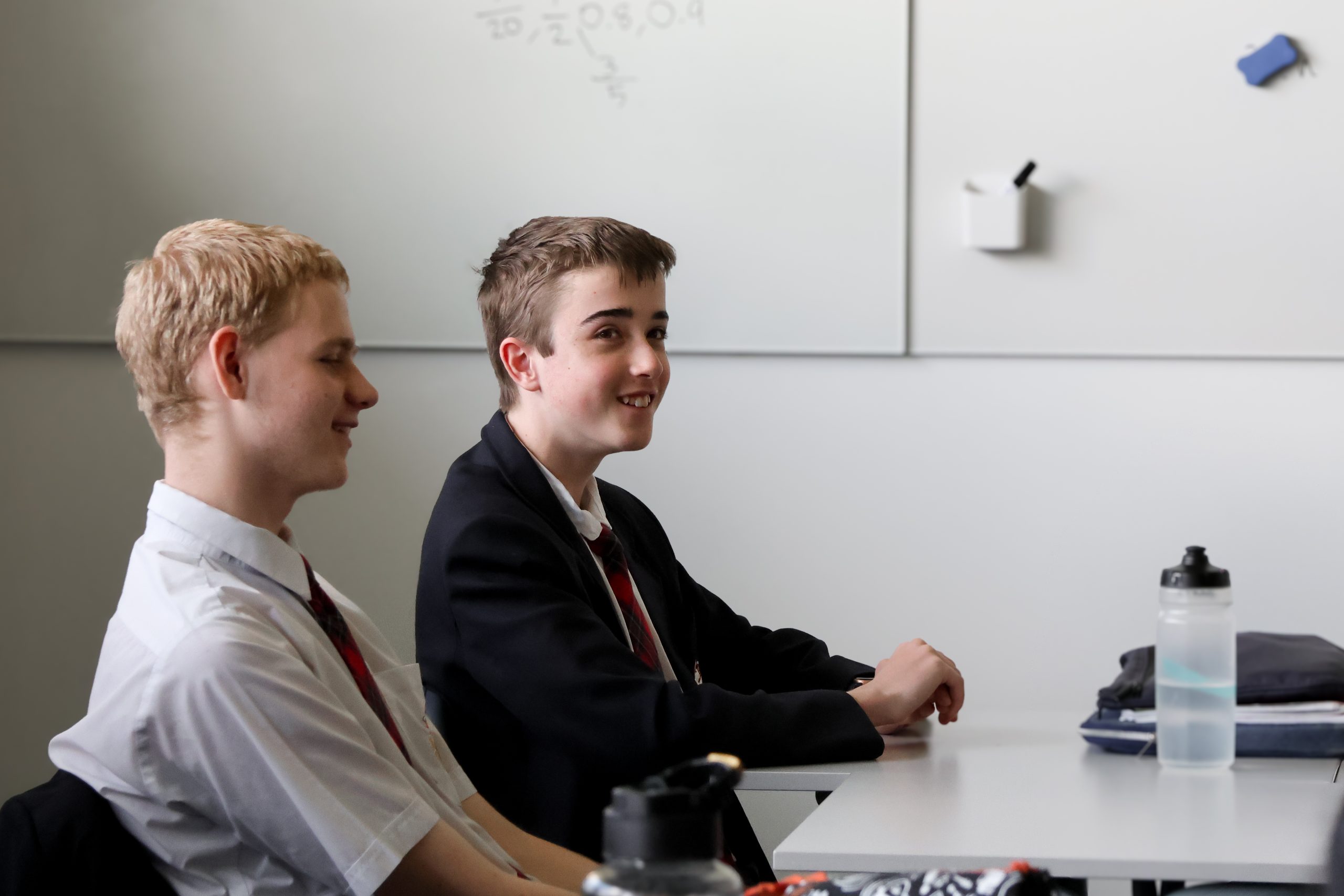 a group of boys sitting at a desk