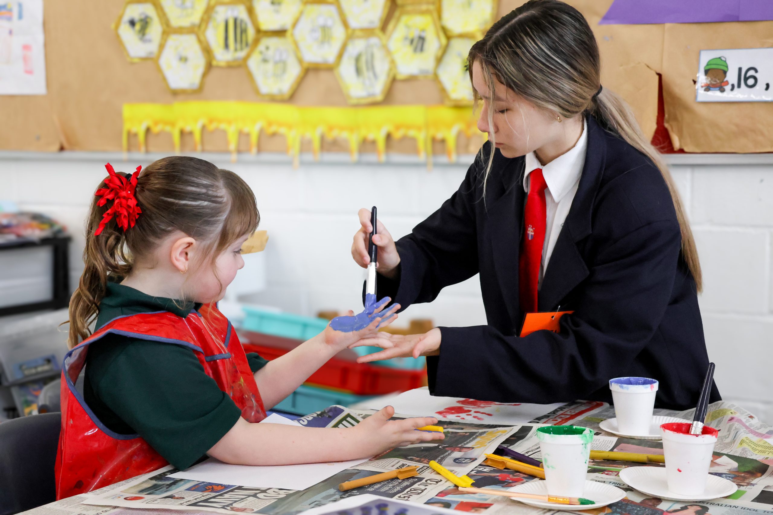 a woman painting a child's hand